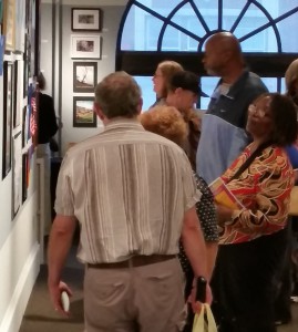 A group of gallery attendees view the mental wellness programs art on the walls at Vision 2015
