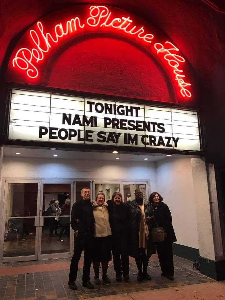 A group of CHOICE advocated pose for a photo outside the Pelham Picture Movie House under the marquee for the film, People Say I'm Crazy